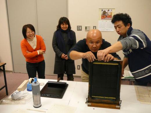 技師を取り囲む人々/