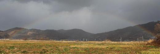 北の山すそにうっすらと虹がかかりました 端から端まで虹を初めて写真に撮りました 冷たい風が吹き 晴れたり雨が降ったりと目まぐるしく天候が変わります 初冬の風景です/