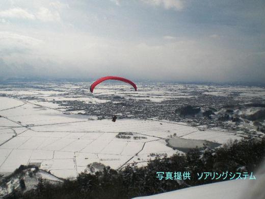 「赤湯冬点描6」雪原に向かって飛び立っていくパラグライダー 我が家の窓から見える十分一山のパラグライダーのランディングから冬でも飛び立つことがあります 寒いでしょうが銀色に輝く赤湯の街も格別だろうと思います ソアリングシステムより提供いただいた写真をアップします これも赤湯の冬の風物詩の一つではないでしょうか/