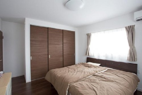 床と建具をブラウンで統一した落ち着きのある寝室：画像