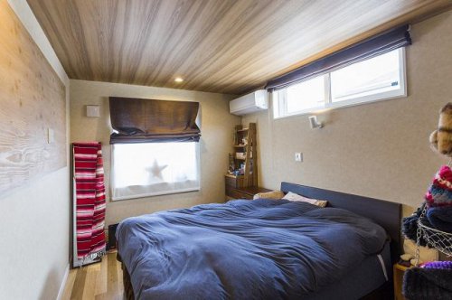 木目調のデザインクロスで暖かみのある寝室：画像